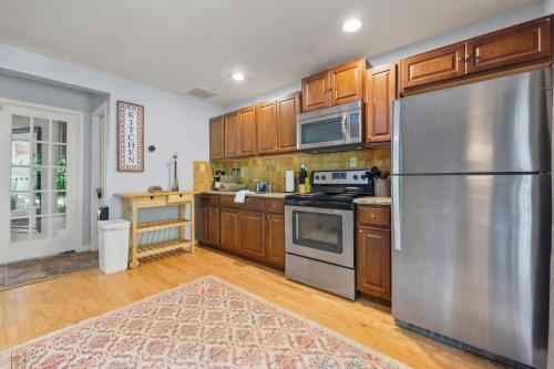 a kitchen with wooden cabinets and a stainless steel refrigerator at Pool and Patio, 8 minutes from Mall of Georgia! in Buford