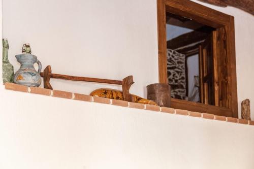 a shelf with vases and a mirror on a wall at Domm'e Antoni in Baunei