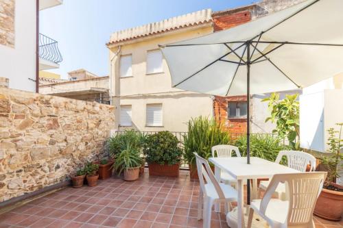 a patio with an umbrella and a table and chairs at Domm'e Antoni in Baunei