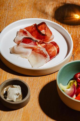 a plate of food on a table with a bowl of fruit at Tenuta Borgo Santa Cecilia in Gubbio