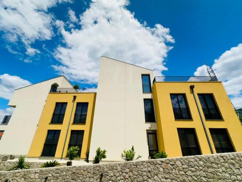 two yellow and white buildings behind a stone wall at Adriatic Dream in Tivat