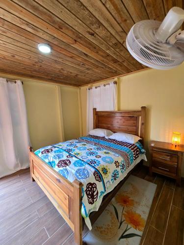 a bedroom with a bed and a wooden ceiling at La Casita De La Cueva in Cabo Rojo