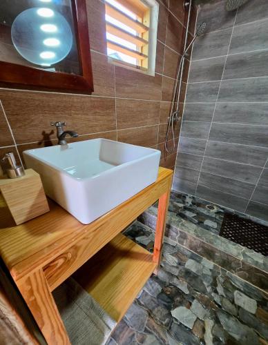 a bathroom with a white sink and a shower at La Casita De La Cueva in Cabo Rojo