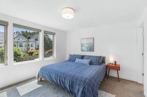 a bedroom with a bed and two windows at Golden Gardens Getaway-Walk to Beach & Waterfront in Seattle