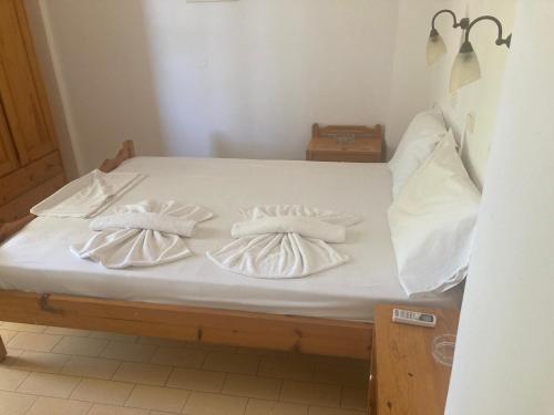 a bed with white sheets and pillows on it at Liberty-Studio Ν5 in Georgioupolis