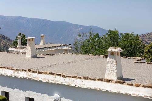 a roof of a building with mountains in the background at Villa Turistica de Bubion in Bubión