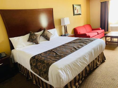 a hotel room with a large bed and a red chair at Luxury Inn in Collingwood