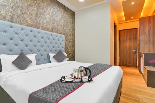 a hotel room with a bed with a tray on it at Super Collection O Hotel Blueline in Juhi Bari