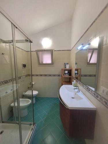 a bathroom with a toilet and a sink and a shower at Villa Stella in Fontane Bianche