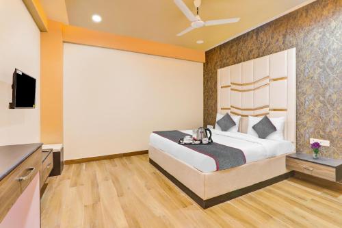 a bedroom with a bed and a flat screen tv at Super Collection O Hotel Blueline in Juhi Bari