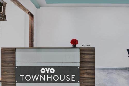 a sign for a townhouse with a red flower on top at Super Collection O Hotel Blueline in Juhi Bari