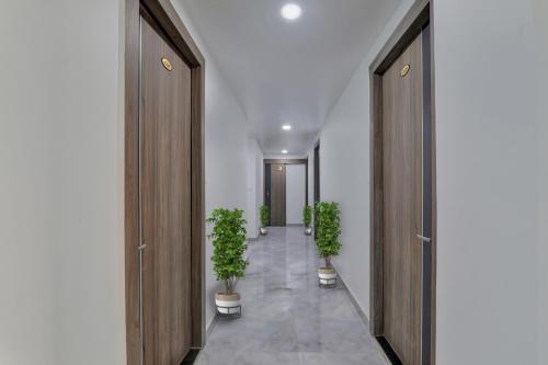 a hallway with two potted plants and two doors at Super Collection O Hotel Blueline in Juhi Bari