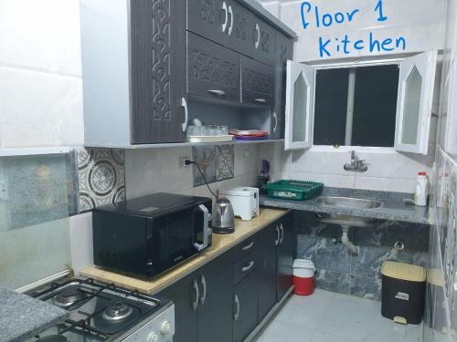 a small kitchen with a microwave and a stove at First Row Sea-Front Chalets Media Village in Marsa Matruh