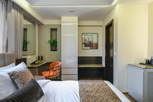 a hotel room with a bed and a desk at Hotel Grand Girdhar Premier in Indore