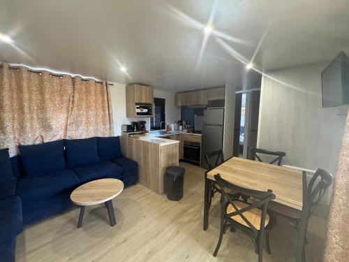 a living room with a blue couch and a table at Nouveau bungalow No 575 Camping 4 étoiles Lac des Rêves in Lattes