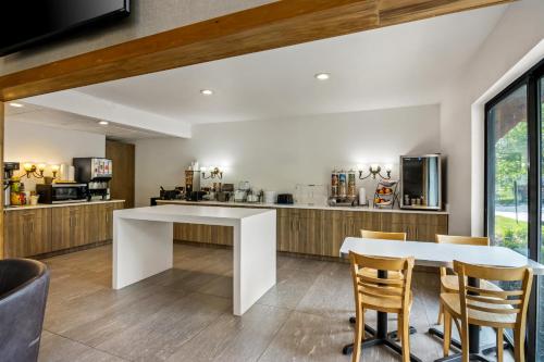 a kitchen and dining room with a white table and chairs at Beachfront Hotel Houghton Lake in Houghton Lake
