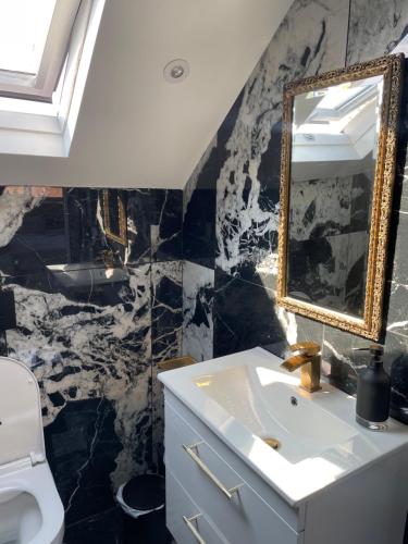 a bathroom with a sink and a mirror at Marble House in Edgware