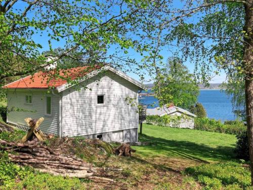 an old white house with a red roof next to the water at 4 person holiday home in H viksn s in Höviksnäs