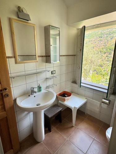 a bathroom with a sink and a mirror and a window at La casa di Filippo e Filippa in Gioiosa Marea