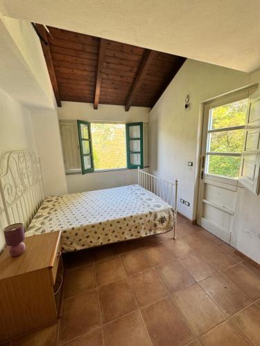 a bedroom with a bed in a room with two windows at La casa di Filippo e Filippa in Gioiosa Marea