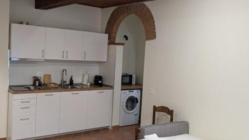a kitchen with white cabinets and a washing machine at Agriturismo Amici Miei in Marliano
