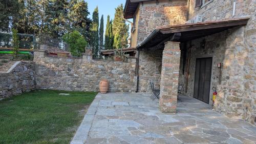 a stone house with a stone wall and a courtyard at Agriturismo Amici Miei in Marliano