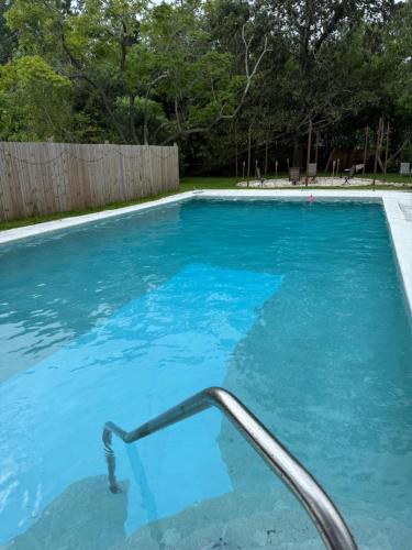 a blue swimming pool with a metal hand rail at Emperors Pool House in Jacksonville