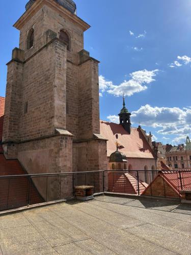 an old building with a clock tower on a street at Hotel Continental in Plzeň