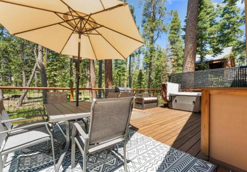 a patio with a table and an umbrella at Lewis Ave Lodge in Tahoma