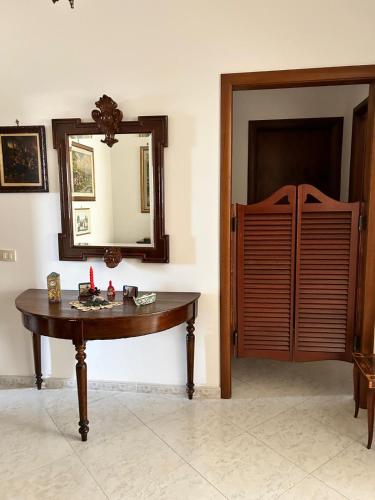 a room with a wooden table and a mirror at Casa Mirella in Aspra