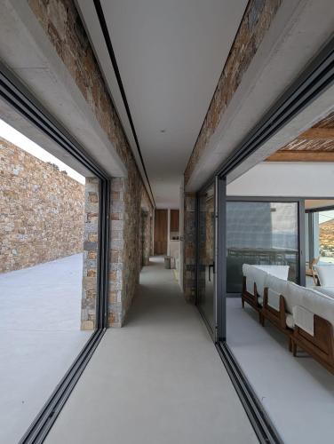a room with glass doors and a brick wall at Katokia Kokkina in Finikas