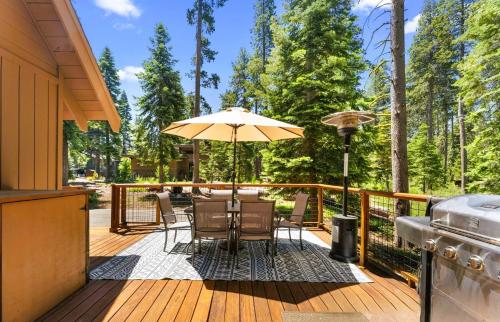 a wooden deck with a table and an umbrella at Lewis Ave Lodge in Tahoma