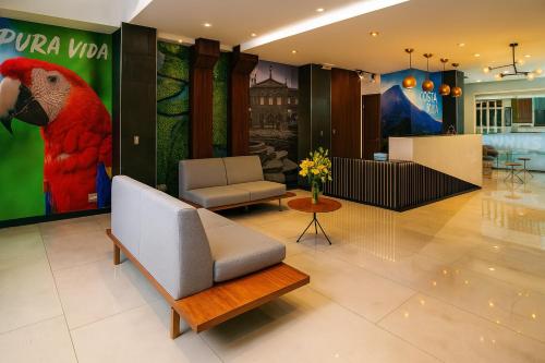 un hall d'entrée avec une peinture de perroquet sur le mur dans l'établissement Hotel Cultura Plaza, à San José