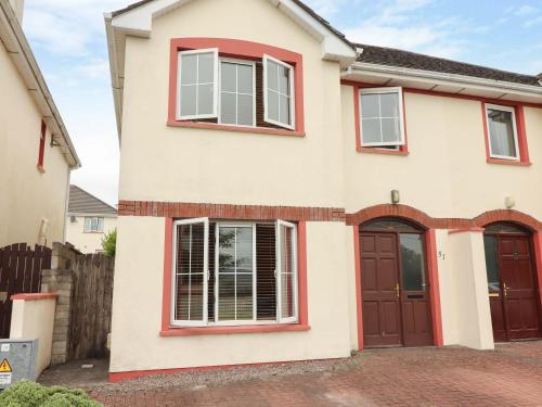 a house with red doors and a fence at 51 Woodview Park in Tralee