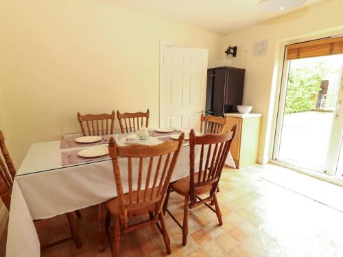 a dining room with a table and chairs and a kitchen at 51 Woodview Park in Tralee