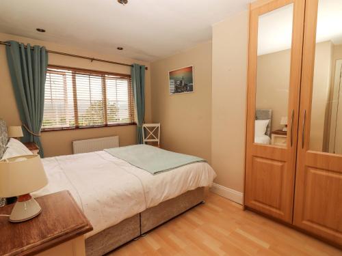 a bedroom with a bed and a window at 51 Woodview Park in Tralee