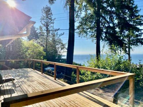 una terraza de madera con vistas al océano en Cedar House Ocean View & Access, en Roberts Creek