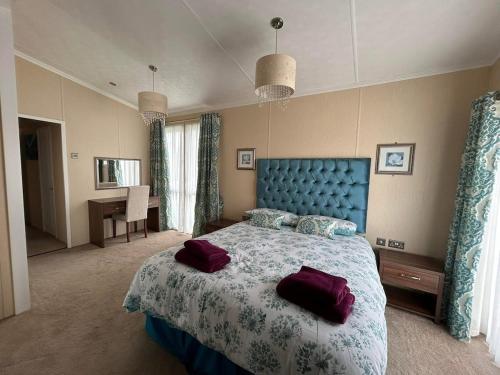 a bedroom with a large bed with purple pillows on it at Rivendale Lodge in Burghead