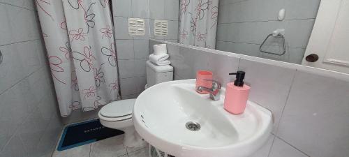 a bathroom with a white sink and a toilet at Rbkº Acogedor depto cercano a Playa Amarilla in Concón
