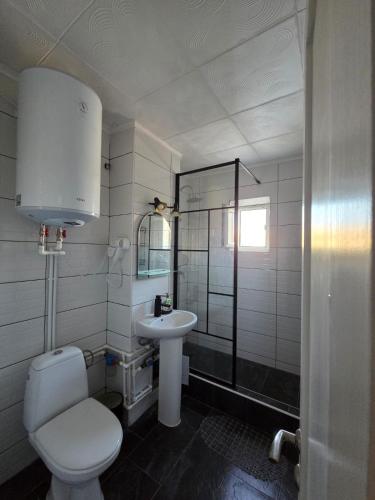 a white bathroom with a toilet and a sink at Apartament Milan in Mangalia
