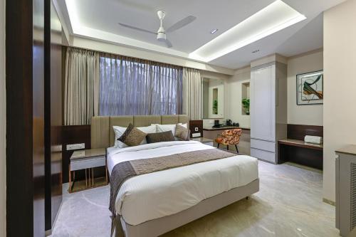 a bedroom with a large bed and a desk at Hotel Grand Girdhar Premier in Indore