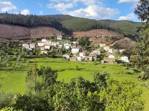 ein kleines Dorf auf einer grünen Wiese in den Bergen in der Unterkunft Casa do Freire - Serra da Estrela in Aguincho