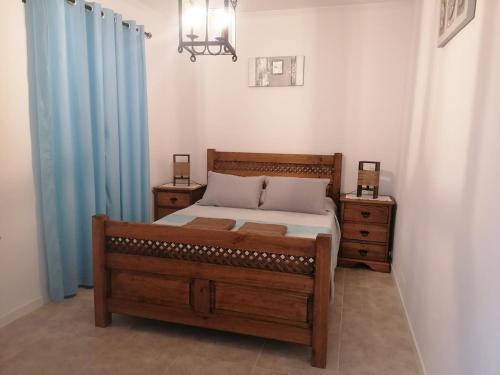a bedroom with a wooden bed and two night stands at Casa da Tia Bia in Venda