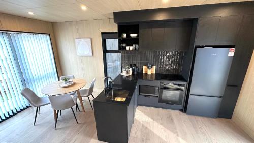 a kitchen with a table and a refrigerator and a dining room at Vibrant Frankton Villa in Queenstown