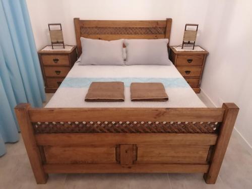 a bedroom with a wooden bed with two night stands at Casa da Tia Bia in Venda