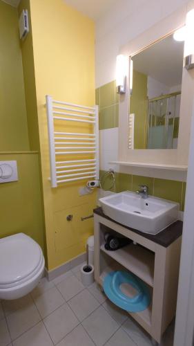 ein Badezimmer mit Waschbecken, Toilette und Spiegel in der Unterkunft Charmant cottage dans Village Normandy Garden, Pierre & Vacances in Branville