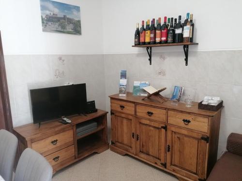 a room with a television and a cabinet with bottles of wine at Casa da Tia Bia in Venda