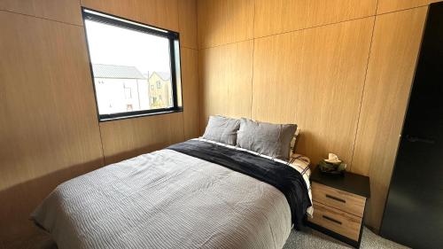 Un dormitorio con una cama grande y una ventana en Vibrant Frankton Villa, en Queenstown
