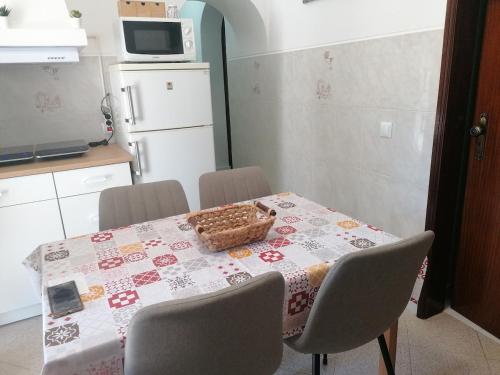 a kitchen table with a table cloth with a basket on it at Casa da Tia Bia in Venda