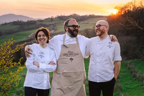 a group of three chefs standing in a field at Tenuta Borgo Santa Cecilia in Gubbio